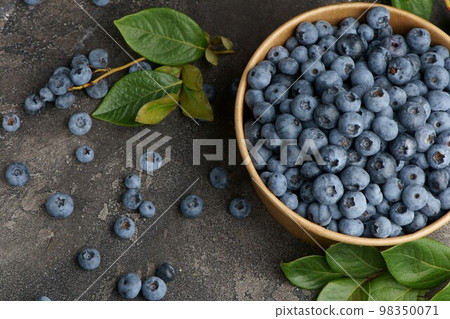 Fresh blueberries with water drops in a wooden bowl. View from above. The concept of healthy and diet food 98350071