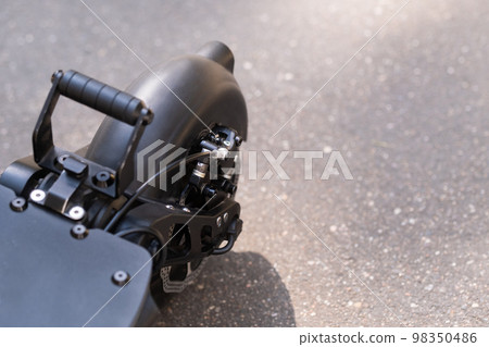 Rear wing with electric scooter wheel on asphalt background in sunny weather Rear wing with electric scooter wheel on asphalt background in sunny weather 98350486