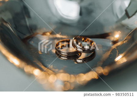 Designer wedding rings lying on the surface. Two wedding rings Designer wedding rings lying on the surface. Two wedding rings 98350511