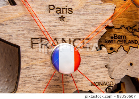 France flag on the pushpin with red thread showed the paths of movement or areas of influence in the global economy on the wooden map. Planning of traveling or logistic concept. Network connection. France flag on the pushpin with red thread showed the paths of movement or areas of influence in the global economy on the wooden map. Planning of traveling or logistic concept. Network connection. 98350607