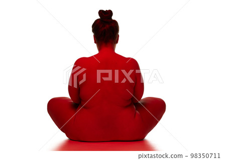 Portrait of naked nude woman posing over white background. Back view. Concept of beauty of overweight female body, bodypositive, fashion. Red light on skin 98350711