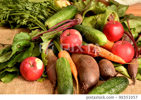 The harvest of vegetables and fruits lies on burlap. The harvest of vegetables and fruits lies on burlap. 98351057