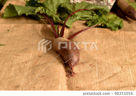 The fruit of the red beet lies on the table. 98351058