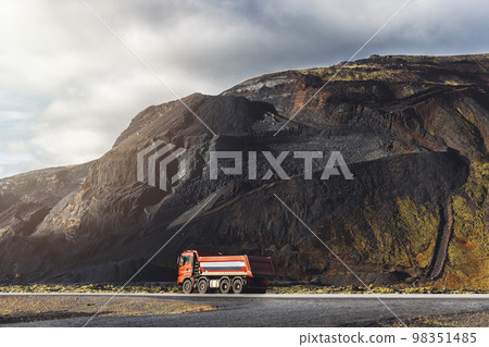 Truck driving from Volcanic red stone quarry in Iceland Truck driving from Volcanic red stone quarry in Iceland 98351485