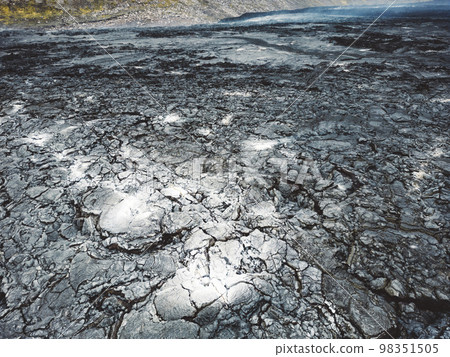 Aerial view of cooled down lava rocks with ash grey spots on the surface in the valley near Geldingadalir volcano 98351505
