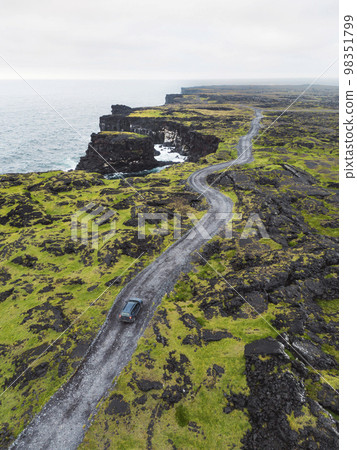 Rocky road by the black volcanic rocky ocean coast - Iceland 98351799