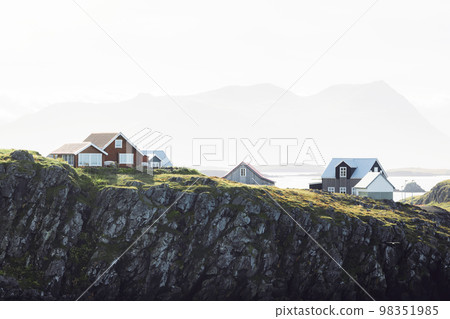 Red typical Icelandic wooden houses on the edge of a cliff near sea - Stykkisholmur 98351985