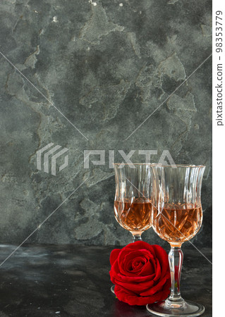 Close up two glasses of liquor and a rose on a black background. 98353779