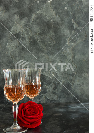 Close up two glasses of liquor and a rose on a black background. Close up two glasses of liquor and a rose on a black background. 98353785