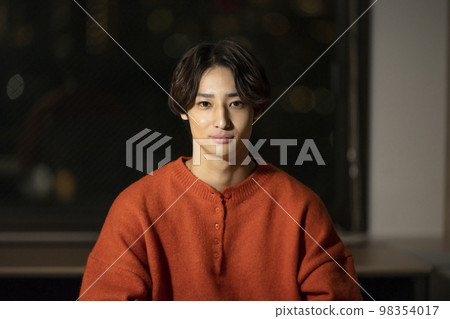 一個二十多歲的男人看著相機，夜間肖像 98354017