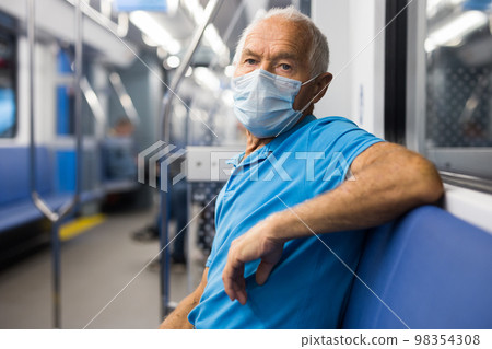 Portrait of male passenger riding in subway car in medical mask to prevent respiratory infection of Covid 19 Portrait of male passenger riding in subway car in medical mask to prevent respiratory infection of Covid 19 98354308