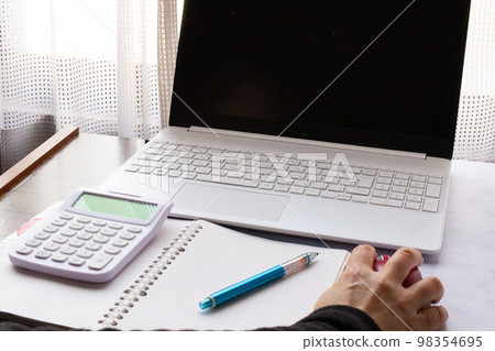 Saving image of keeping a household account book on a computer indoors Saving image of keeping a household account book on a computer indoors 98354695