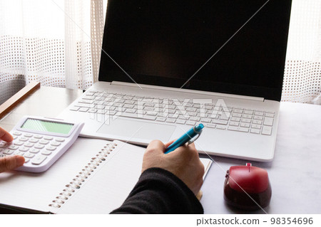 Saving image of keeping a household account book on a computer indoors Saving image of keeping a household account book on a computer indoors 98354696