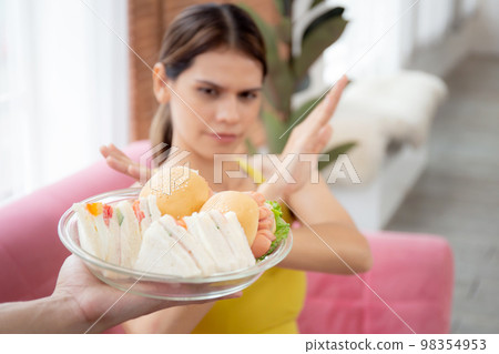 Hands serving food and young caucasian woman making sign say no food unhealthy with obese. Hands serving food and young caucasian woman making sign say no food unhealthy with obese. 98354953