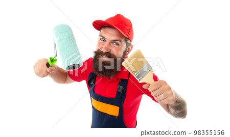 cheerful decorator with paintroller in uniform. decorator with paintroller in studio. decorator 98355156