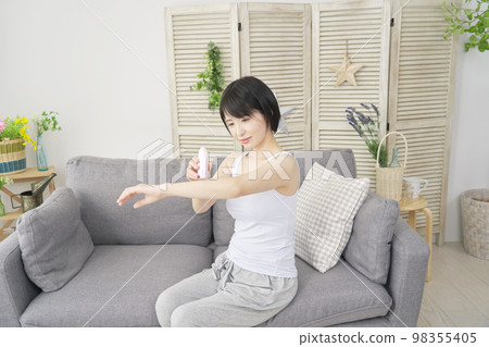 Woman doing arm self hair removal at home 98355405