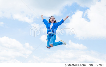cheerful child jump in casual denim apparel outdoor, happiness 98355780