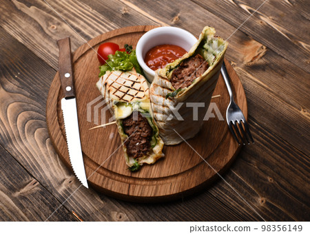Burrito or tortilla served in restaurant, cafe. Flatbread with pork 98356149