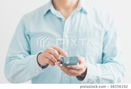 一個在手邊使用智能手機零件的中年男子 98356192