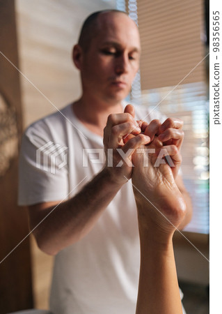 Close-up vertical shot of male orthopedic doctor doing massage of foot and lower leg of unrecognizable female patient after injury Sprained ankle in the clinic. Concept of luxury professional massage. Close-up vertical shot of male orthopedic doctor doing massage of foot and lower leg of unrecognizable female patient after injury Sprained ankle in the clinic. Concept of luxury professional massage. 98356565