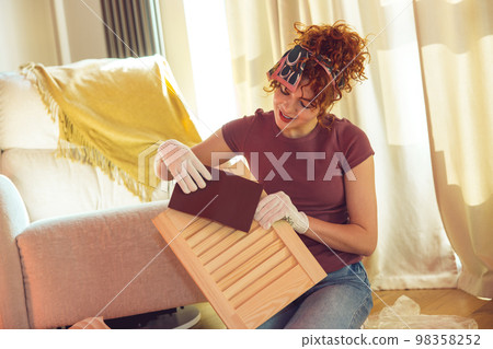 Ginger cute young woman making a workshop on painting the wood 98358252