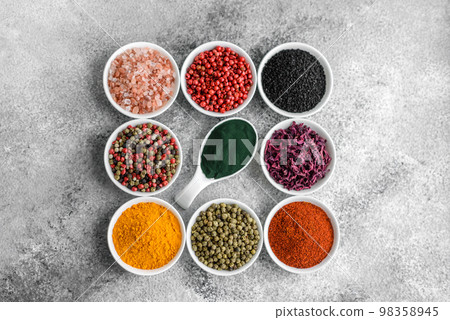 Composition consisting of a variation of several types of spices in white ceramic bowls Composition consisting of a variation of several types of spices in white ceramic bowls 98358945