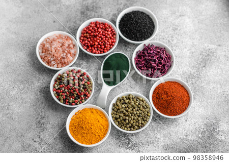 Composition consisting of a variation of several types of spices in white ceramic bowls Composition consisting of a variation of several types of spices in white ceramic bowls 98358946