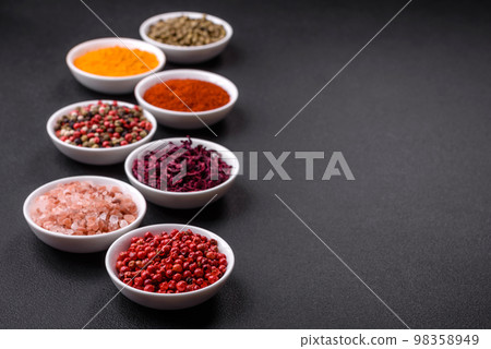 Composition consisting of a variation of several types of spices in white ceramic bowls Composition consisting of a variation of several types of spices in white ceramic bowls 98358949