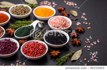 Composition consisting of a variation of several types of spices in white ceramic bowls 98358963
