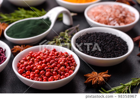Composition consisting of a variation of several types of spices in white ceramic bowls 98358967