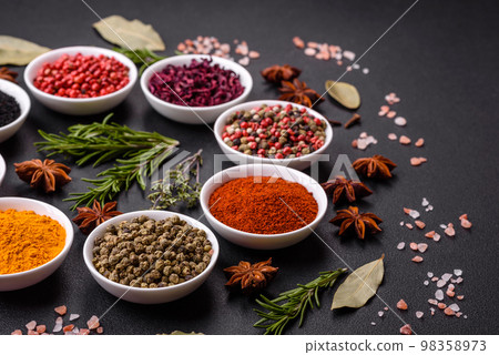 Composition consisting of a variation of several types of spices in white ceramic bowls 98358973