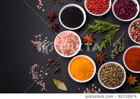 Composition consisting of a variation of several types of spices in white ceramic bowls 98358974