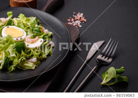 Delicious fresh healthy salad with shrimp, egg, lettuce and flax seeds 98359063
