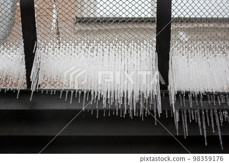 Icicles on wires near street houses. winter season nature Icicles on wires near street houses. winter season nature 98359176