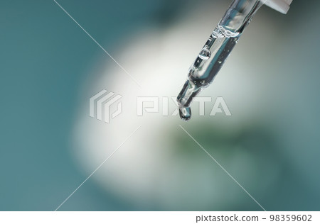 Closeup of face serum in transparent glass pipette. Natural oil, gel, cleaner. Anti age cosmetics and healthcare concept in macro. Dose of retinol. Virus research. Web banner for design 98359602