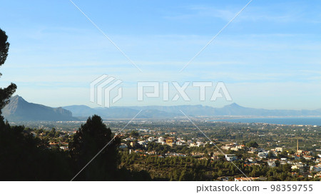Panoramic view from height of Mediterranean resort seaside town Denia, roofs of the houses, sea in the distance, beautiful landscape Panoramic view from height of Mediterranean resort seaside town Denia, roofs of the houses, sea in the distance, beautiful landscape 98359755