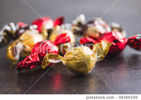 Sweet candy wrapped in foil on kitchen table. 98360289