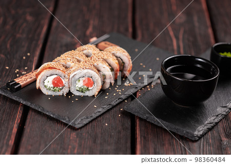 Sushi roll with smoked eel and salmon with cucumber and cheese. Traditional delicious fresh sushi roll set. Sushi menu. Japanese cuisine restaurant. Asian food Sushi roll with smoked eel and salmon with cucumber and cheese. Traditional delicious fresh sushi roll set. Sushi menu. Japanese cuisine restaurant. Asian food 98360484