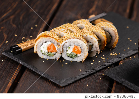 Sushi roll with smoked eel and salmon with cucumber and cheese. Traditional delicious fresh sushi roll set. Sushi menu. Japanese cuisine restaurant. Asian food Sushi roll with smoked eel and salmon with cucumber and cheese. Traditional delicious fresh sushi roll set. Sushi menu. Japanese cuisine restaurant. Asian food 98360485