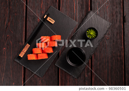 California sushi roll with crab, avocado, cucumber and tobiko caviar served on black board top view - Japanese food California sushi roll with crab, avocado, cucumber and tobiko caviar served on black board top view - Japanese food 98360501