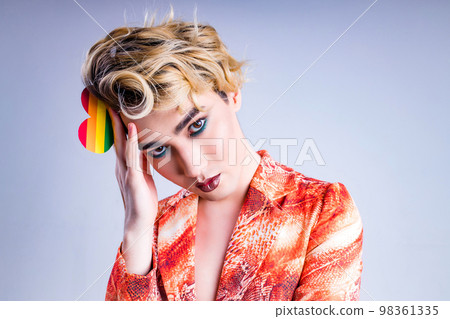 Closeup portrait of a young man with a lipstick over white background Closeup portrait of a young man with a lipstick over white background 98361335