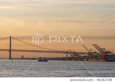 Industrial cranes by the river at early evening 98362596