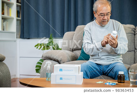Asian old man buy herbal self cure Rx pill online from pharmacy, worried senior man with medicine pills he read on see how to take pills before taking, home isolation, Medical service concept 98363453