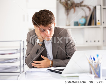 Businessman works in the office - puts documents in order and draws up contract 98365396