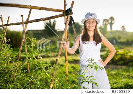 Portrait of smiling contented young woman in garden on sunny day 98365529