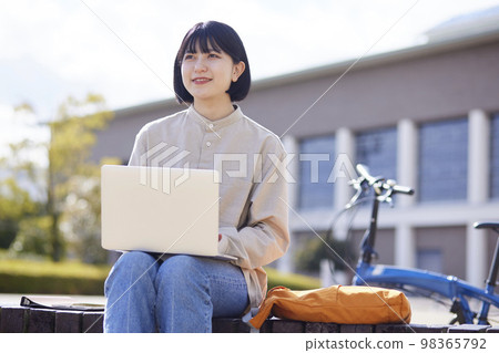A young Japanese woman studying at university using a laptop computer. A young Japanese woman studying at university using a laptop computer. 98365792