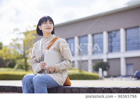 A young Japanese woman with a laptop on campus A young Japanese woman with a laptop on campus 98365798