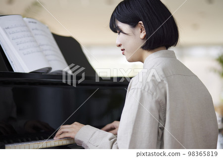 Young Japanese woman playing the piano 98365819