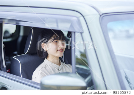 Young Japanese woman driving a car Young Japanese woman driving a car 98365873