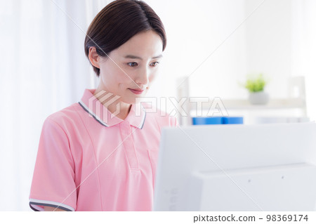 caregiver looking at a computer 98369174